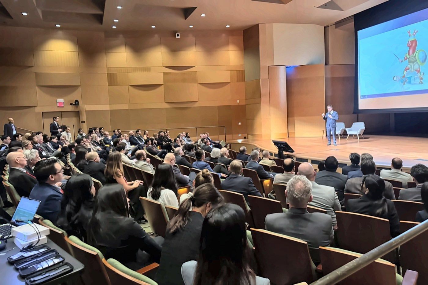 Speaker presenting to a full auditorium at the Huntington Library